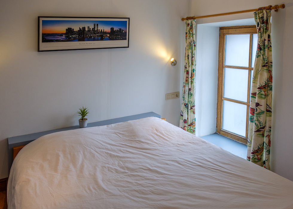Slaapkamer met twee eenpersoonsbedden en een tweepersoonsbed. De doucheruimte bevindt zich op de overloop.