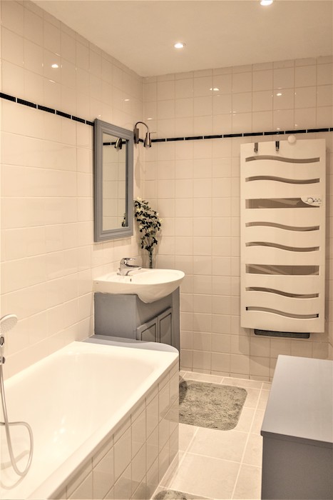 Badkamer voorzien van een ligbad en een wastafel.