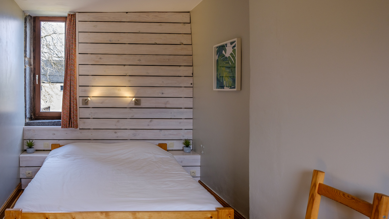 Schlafzimmer mit einem Doppelbett. Waschbecken im Zimmer und bad auf dem Treppenabsatz.