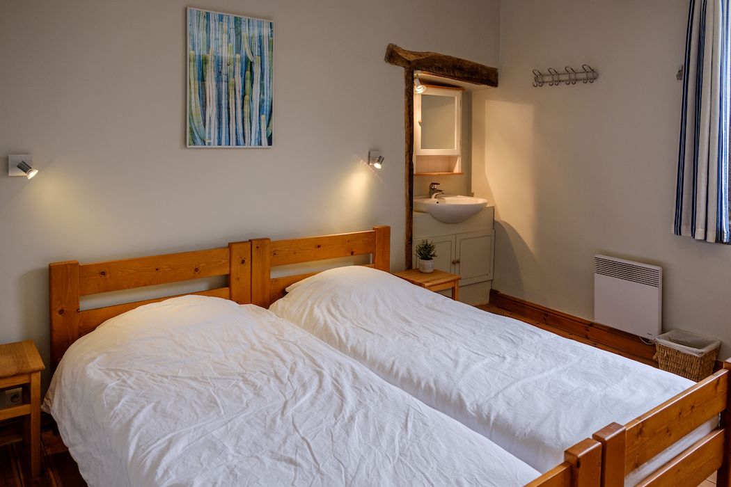Chambre avec deux lits simples. Lavabo dans la chambre et salle de bains sur le palier.